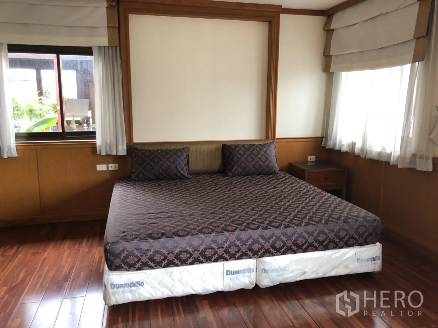 房间 出租在Bang Rak, Bangkok - 宽敞主卧，木质装饰与两面采光的大床