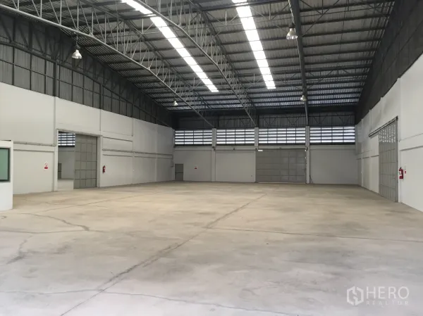 工厂 出租在Si Racha, Chon Buri - 厂房内部宽敞，高钢梁屋顶、天窗与百叶通风口，抛光混凝土地面。