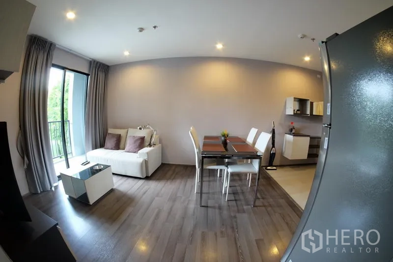 公寓 出租在Watthana, Bangkok - 采光良好的客厅，设沙发与餐桌，落地玻璃门通往绿景阳台。