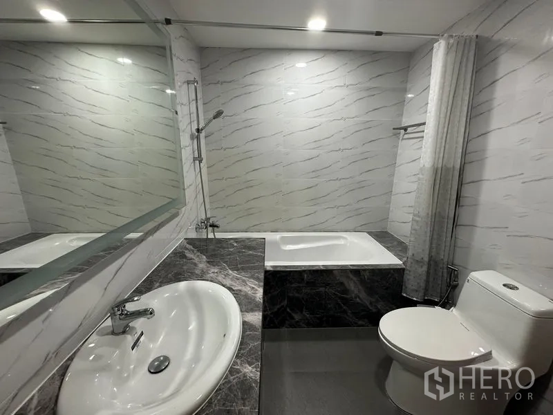 คอนโด ให้เช่าในWatthana, Bangkok - ห้องน้ำสมัยใหม่พร้อมอ่างล้างหน้าเคาน์เตอร์หินอ่อน อ่างอาบน้ำ และกระจกบานใหญ่