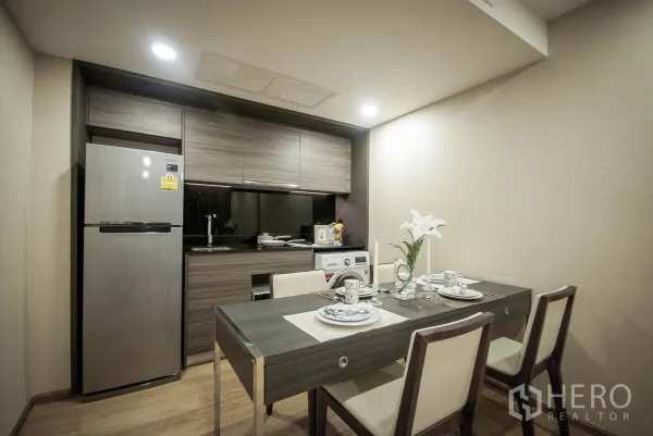 คอนโด ให้เช่าในPathum Wan, Bangkok - ครัวบิลต์อินสไตล์โมเดิร์น ตู้ไม้ ตู้เย็นสแตนเลส อ่างล้างจาน เครื่องซักผ้า และโต๊ะอาหาร 4 ที่นั่ง.