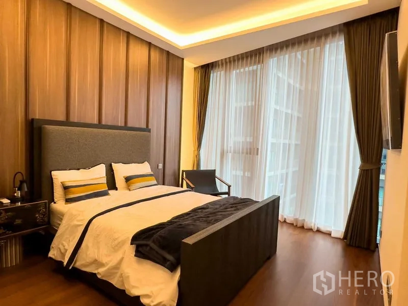 公寓 出售在Khlong Toei, Bangkok - 温馨卧室，木质墙面、大床、纱帘与天花氛围灯。