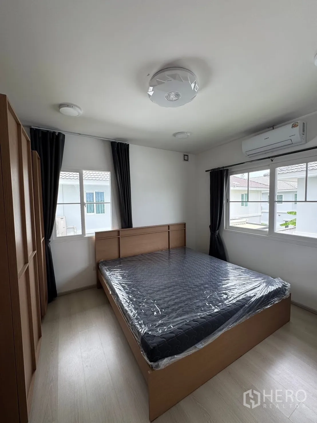 บ้านเดี่ยว for rent in Bang Phli, Samut Prakan - ห้องนอนพร้อมเตียงไม้ ตู้เสื้อผ้า และเครื่องปรับอากาศ