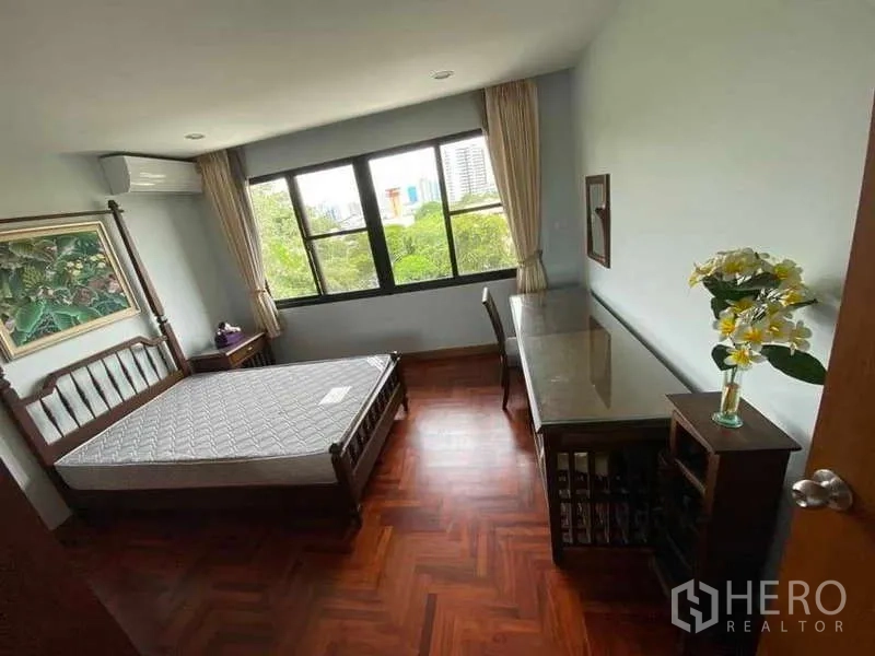 公寓 出租在Sathon, Bangkok - 卧室配床与长书桌，窗外为绿意景观。