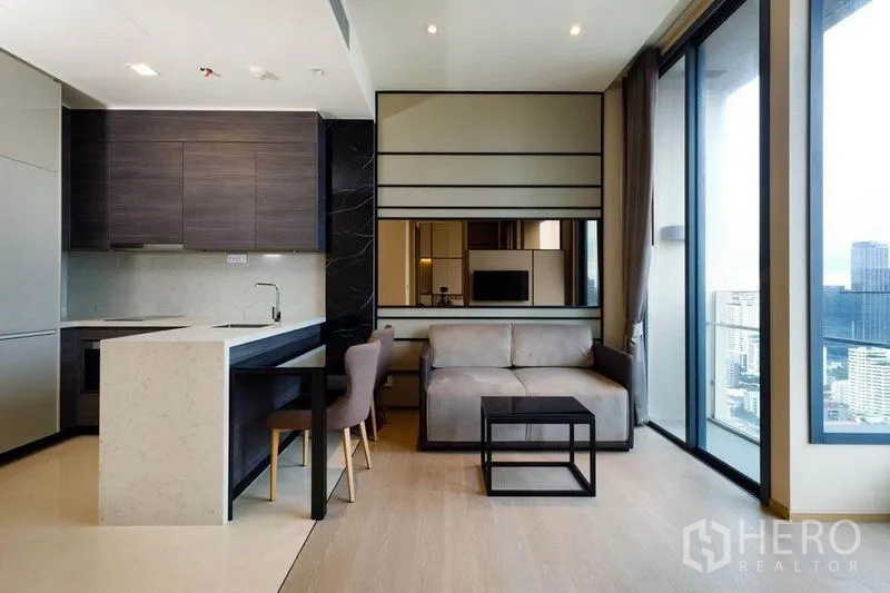 Condominium for rent or sale in Watthana, Bangkok - Living area with marble-top breakfast bar, sofa and floor-to-ceiling windows overlooking Bangkok.