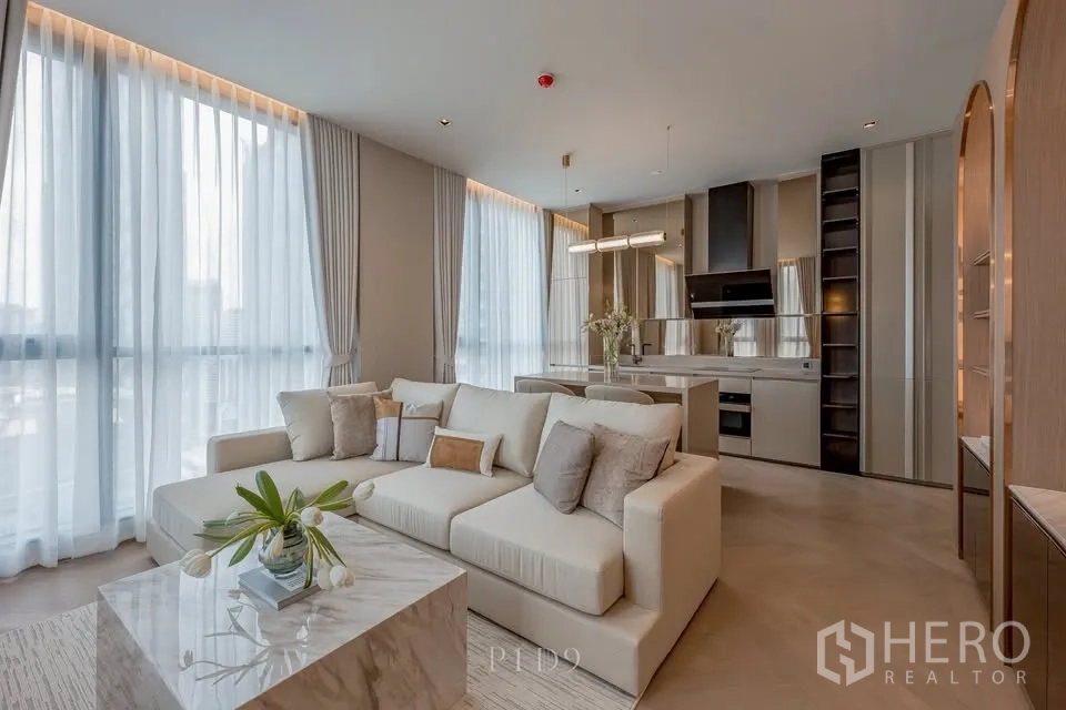 คอนโด for rent in Sathon, Bangkok - ห้องนั่งเล่นสว่างพร้อมโซฟาเข้ามุม โต๊ะกลางลายหิน ครัวแบบเปิด และหน้าต่างเต็มบาน