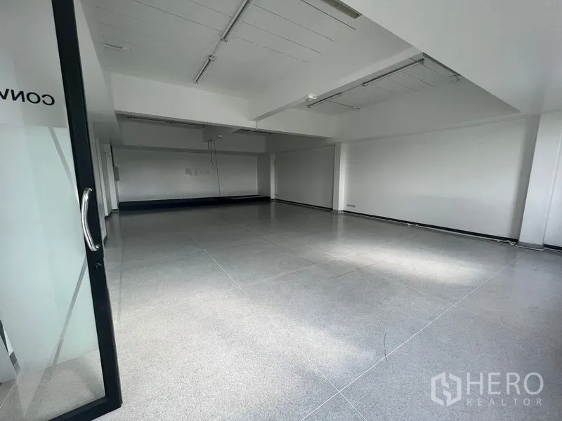 Office Space for rent in Mueang Samut Prakan, Samut Prakan - Bright office viewed through a glass door with a metal handle.