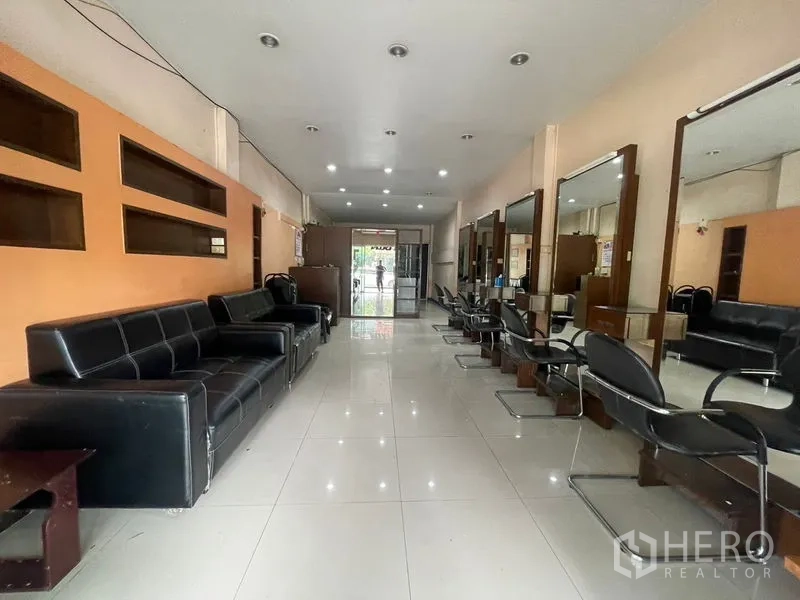 店屋 出租在Phra Khanong, Bangkok - 纵深沙龙式布局，镜面、座椅与嵌灯照明。