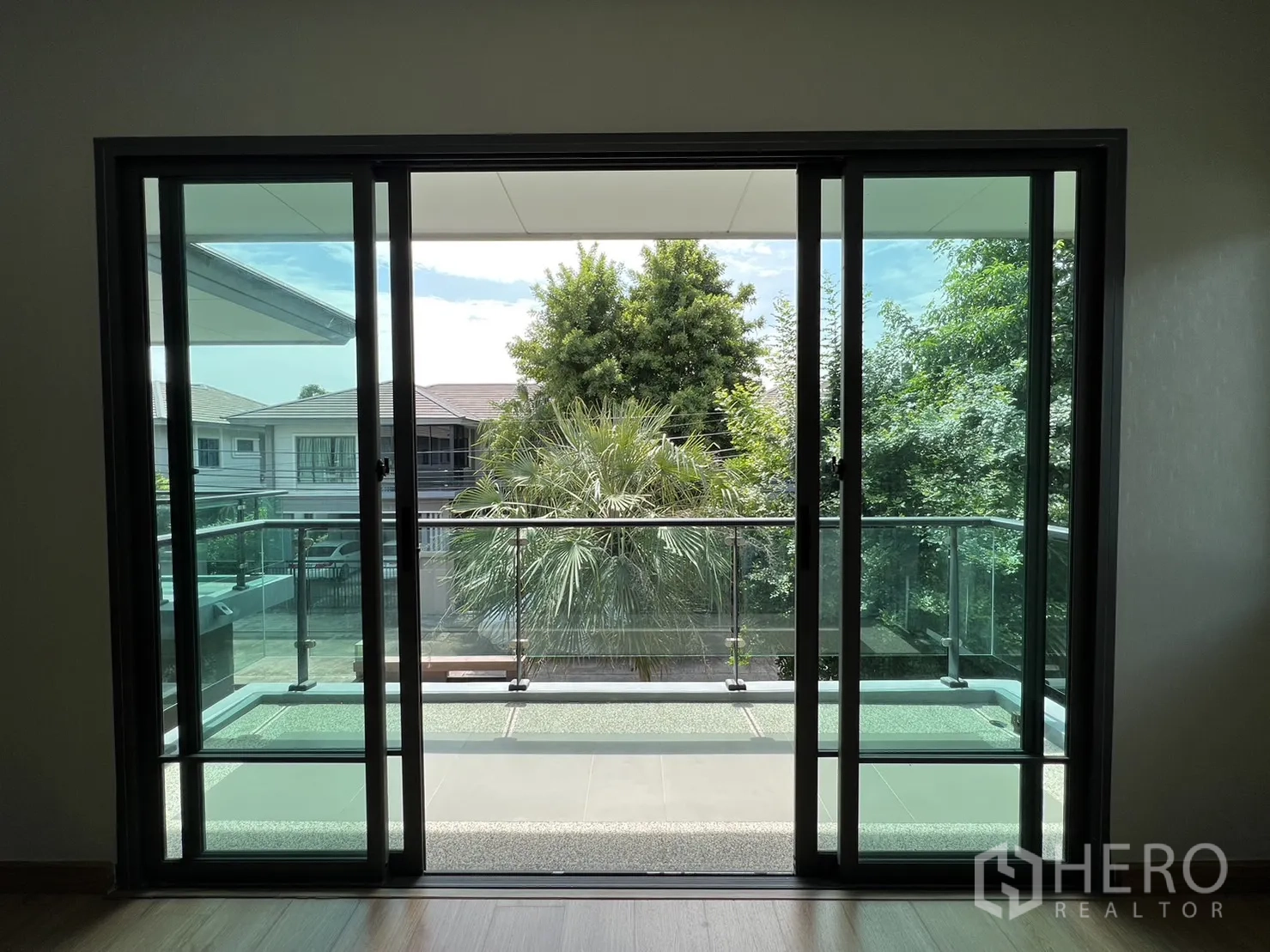 Detached House for sale in Suan Luang, Bangkok - Sliding doors opening to balcony with leafy neighborhood view.