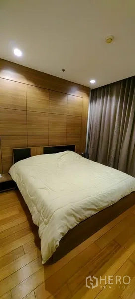 คอนโด ให้เช่าในKhlong San, Bangkok - ห้องนอนใหญ่ ผนังหัวเตียงบุลายไม้ ผ้าม่านทึบ และพื้นไม้