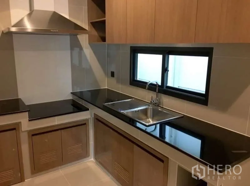 บ้าน ให้เช่าในBang Kapi, Bangkok - ครัวปิดสไตล์โมเดิร์น ท็อปหินสีดำ อ่างล้างจานคู่ และเครื่องดูดควัน