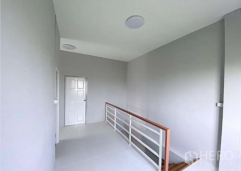 Warehouse for sale in Pathum Thani - Upper-floor landing with white railing and doors leading to office rooms.