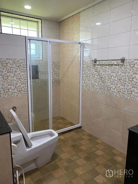 Detached House for sale in Bang Bo, Samut Prakan - Bathroom featuring a glass-enclosed shower, patterned wall tiles, and a window.