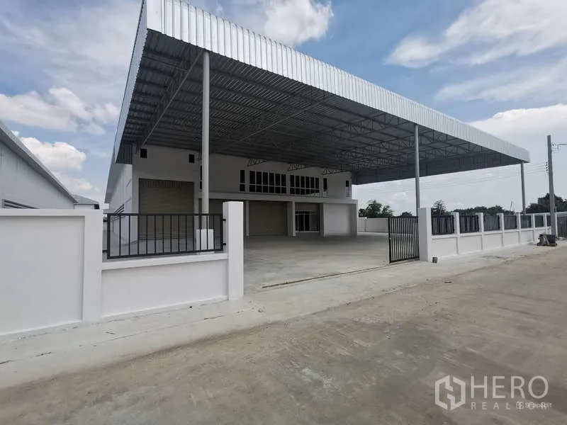 Factory for rent or sale in Bang Bo, Samut Prakan - Street-facing view of the new factory compound with fence and canopy entrance.