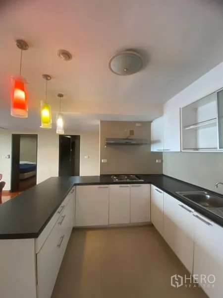 公寓 出租或出售在Watthana, Bangkok - U型厨房，黑色石材台面、白色橱柜、炉灶与抽油烟机