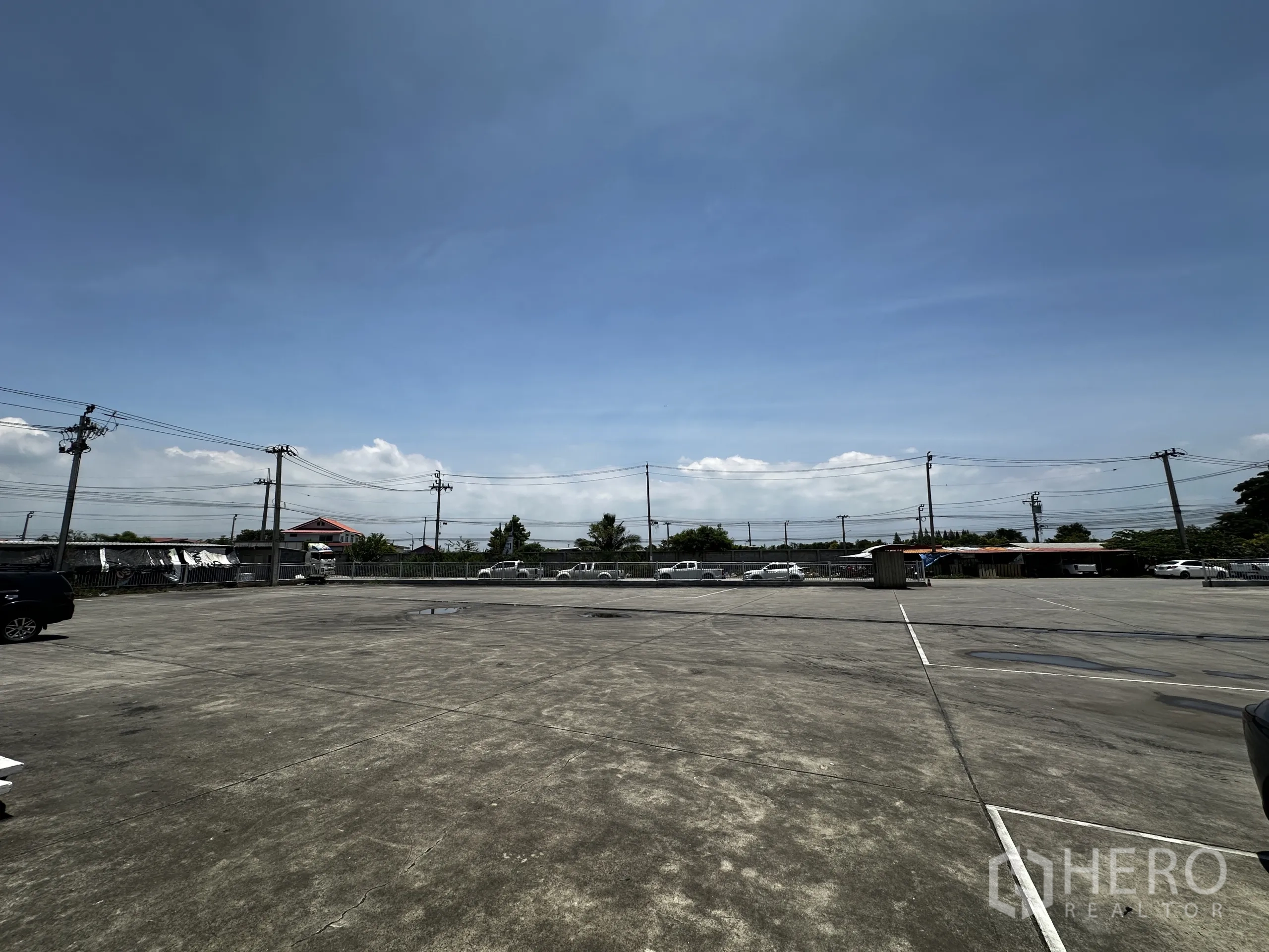 คลังสินค้า ให้เช่า - ลานจอดและลานกองเก็บสินค้าขนาดใหญ่ ล้อมรั้ว มองเห็นเสาไฟฟ้า