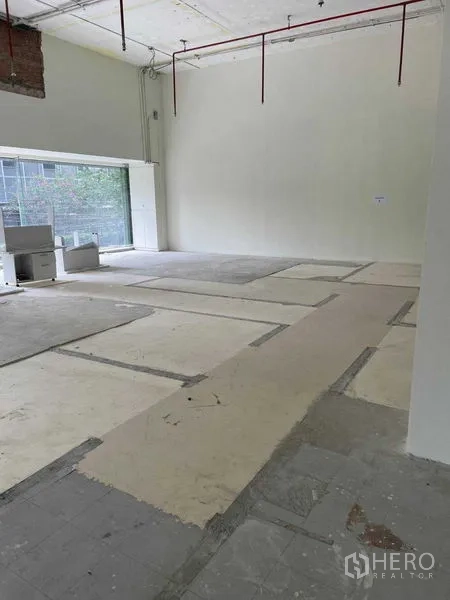 Office Space for rent in Watthana, Bangkok - Spacious corner workspace with glass wall and concrete subfloor ready for fit-out.