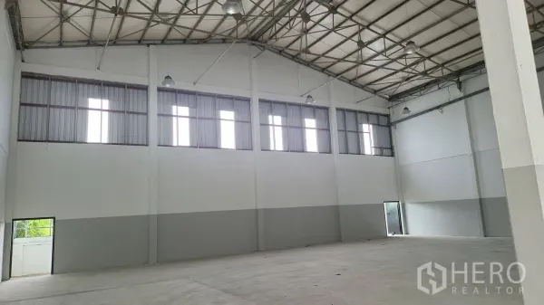 Factory for rent in Bang Phli, Samut Prakan - Spacious warehouse hall with high steel truss roof, clerestory windows and bright lighting.