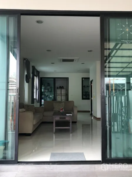 ทาวน์เฮาส์ ขายในPhra Khanong, Bangkok - ประตูบานเลื่อนเปิดสู่ห้องนั่งเล่นสว่าง โซฟาและตู้โชว์