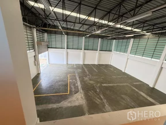 โรงงาน ขายในThanyaburi, Pathum Thani - พื้นที่โกดังเพดานสูง โครงหลังคาเหล็ก มีสกายไลท์และช่องลม ผิวพื้นคอนกรีตขัดมันมีเส้นกำหนดจุดขนถ่าย