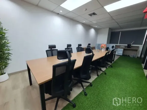 办公空间 出租 - 明亮会议室，长木质会议桌与人体工学椅，走道铺设人工草坪。