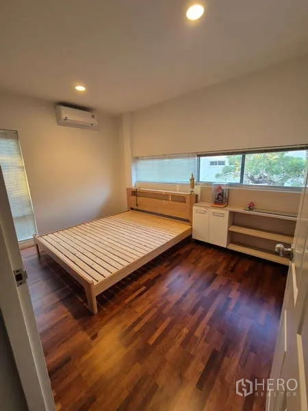 独立式住宅 出租在Bang Kruai, Nonthaburi - 温馨卧室，木框床与长窗置物柜。