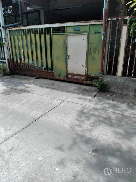 Townhouse for sale - Front driveway of the townhouse with a sliding metal gate for off-street parking.