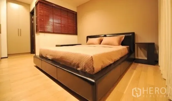 คอนโด ให้เช่าในKhlong Toei, Bangkok - ห้องนอนอบอุ่น เตียงกรอบหนัง พื้นไม้ และมู่ลี่หน้าต่าง พร้อมตู้เสื้อผ้าบิลต์อิน