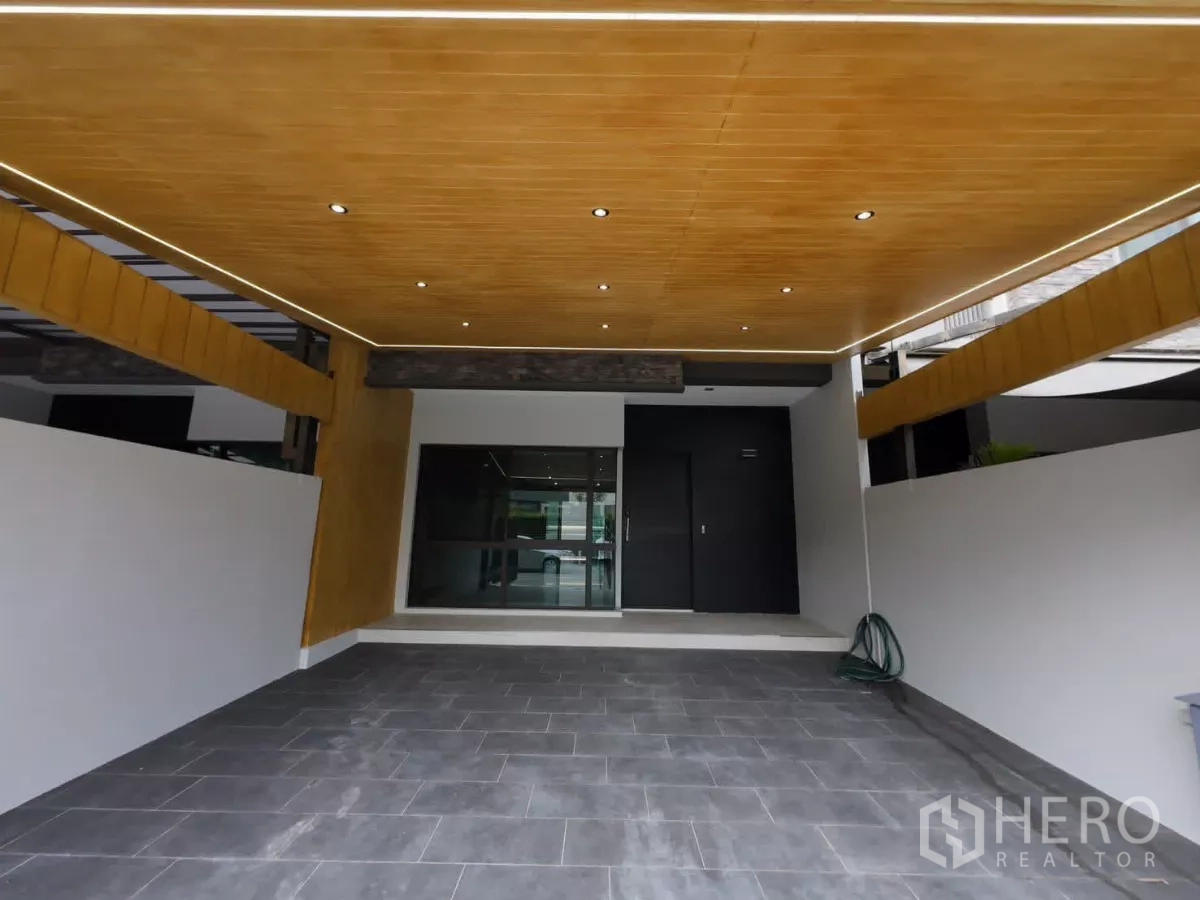 ทาวน์เฮาส์ ให้เช่าหรือขายในLat Phrao, Bangkok - โรงจอดรถเพดานไม้พร้อมไฟดาวน์ไลท์และพื้นกระเบื้อง