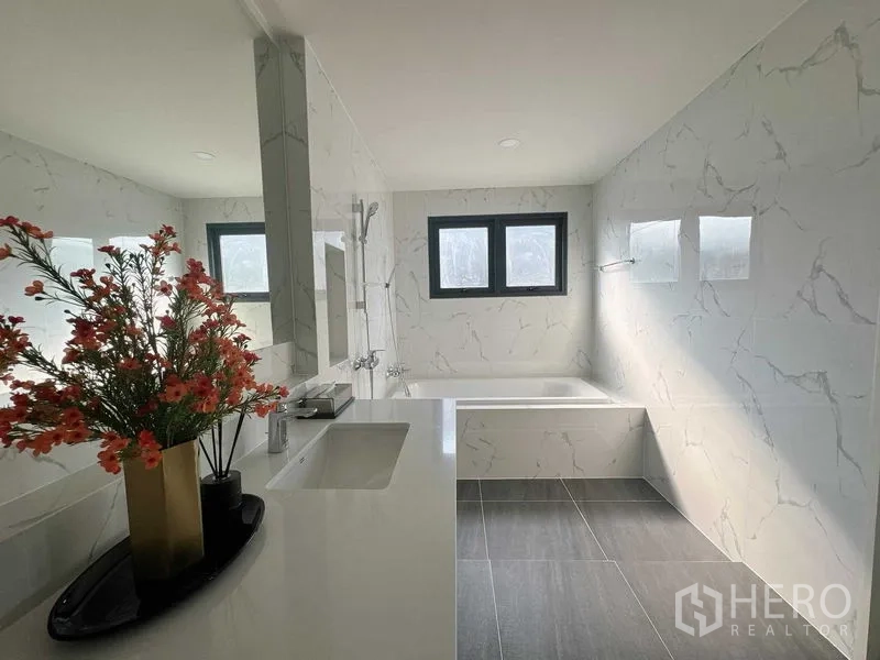 Detached House for rent or sale - Contemporary bathroom with bathtub, long vanity and marble-effect wall tiles.