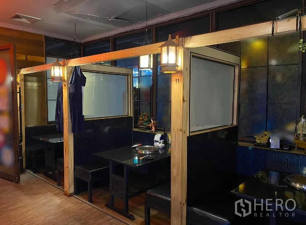 零售空间 出租在Watthana, Bangkok - 木质隔间的卡座用餐区，悬挂灯笼与黑色桌面