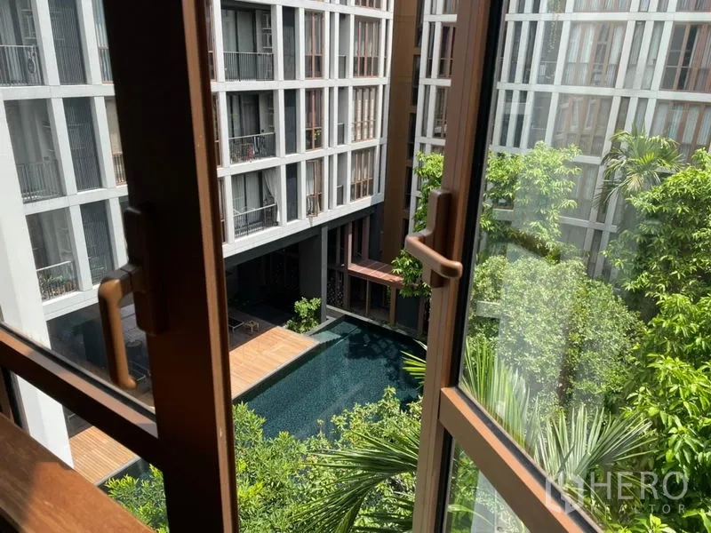 Condominium for sale in Watthana, Bangkok - Window view over the condominium’s lush courtyard and swimming pool.