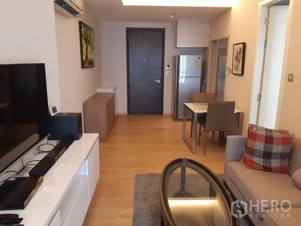 คอนโด ให้เช่าในWatthana, Bangkok - มุมมองจากห้องนั่งเล่นไปทางประตูทางเข้า โต๊ะทานข้าว และครัวยุคใหม่พร้อมตู้เย็น