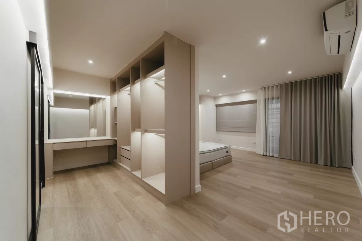 联排别墅 出租在Watthana, Bangkok - 主卧套房，步入式衣帽间、梳妆台与木地板。