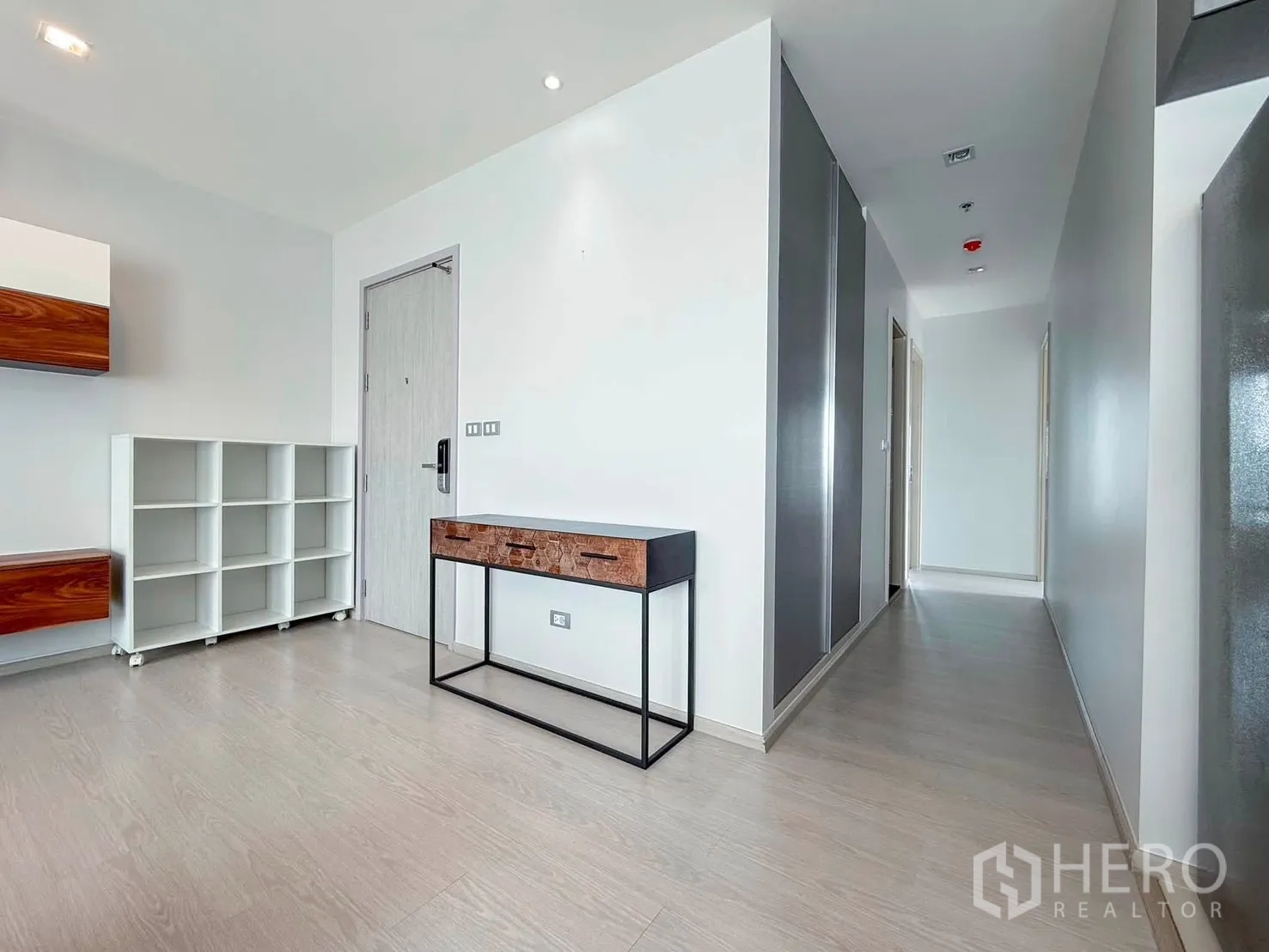 Condominium for rent in Khlong Toei, Bangkok - Entry hall with open shelving, console table, and light wood floors.