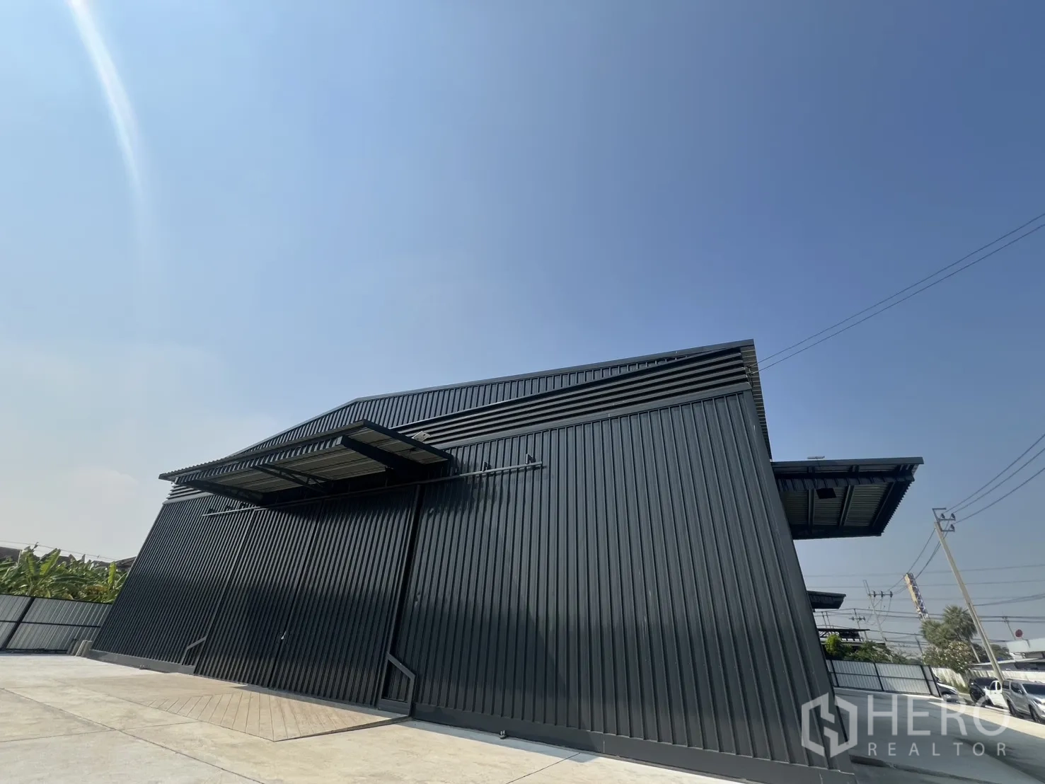 货栈 出租在Lat Krabang, Bangkok - 高挑屋顶仓库仰视外立面，带百叶通风与遮雨装卸平台。