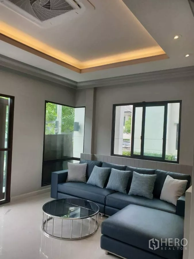 บ้าน ให้เช่าหรือขายในPrawet, Bangkok - มุมนั่งเล่นอบอุ่น โซฟาเข้ามุม หน้าต่างบานใหญ่ และไฟซ่อนฝ้า