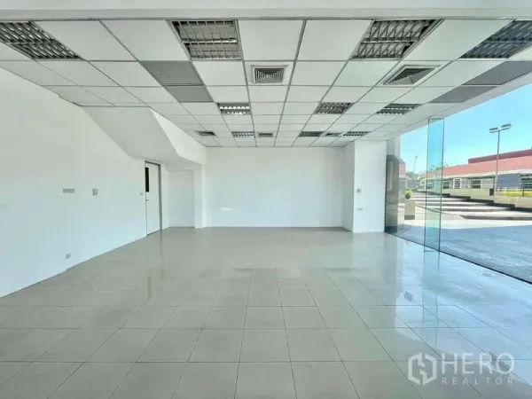 พื้นที่ขายปลีก ให้เช่าในYan Nawa, Bangkok - โถงค้าปลีกแบบเปิดโล่ง เพดานแขวนพร้อมช่องแอร์ และกระจกบานสูงมุมอาคาร.