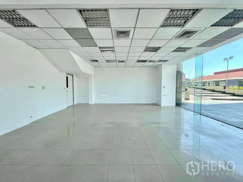 พื้นที่ขายปลีก ให้เช่าในYan Nawa, Bangkok - โถงค้าปลีกแบบเปิดโล่ง เพดานแขวนพร้อมช่องแอร์ และกระจกบานสูงมุมอาคาร.