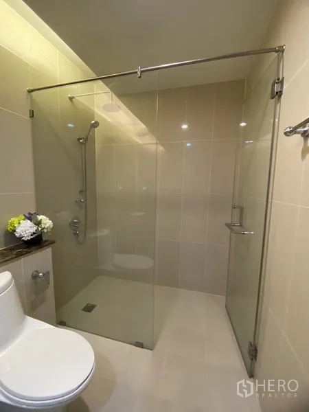 คอนโด ให้เช่าในWatthana, Bangkok - ห้องน้ำสมัยใหม่ กั้นอาบน้ำกระจกใส ฝักบัวโครเมียม โถสุขภัณฑ์ และกระเบื้องโทนครีม