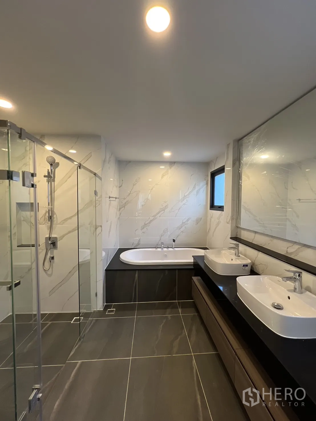 Detached House for rent or sale in Bang Phli, Samut Prakan - Master bathroom with bathtub, double basins and glass-enclosed shower.