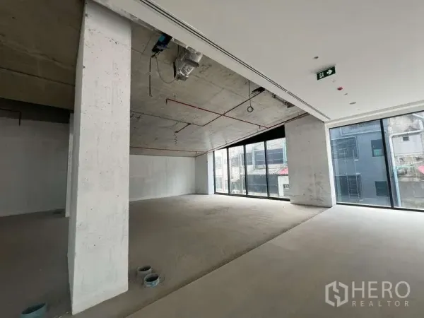 零售空间 出租 - 位于曼谷帕亚泰、临近BTS Sanam Pao 的90㎡开间零售铺，裸露混凝土顶与管线，落地窗采光充足。