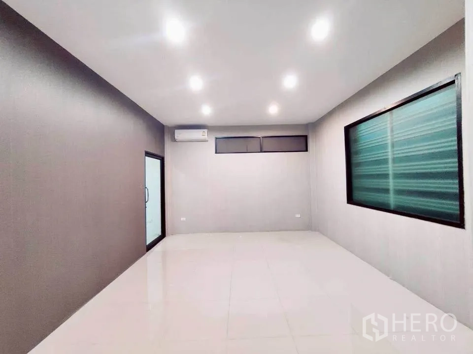 Warehouse for rent in Lam Luk Ka, Pathum Thani - Air-conditioned office room with neutral walls and sliding glass door.