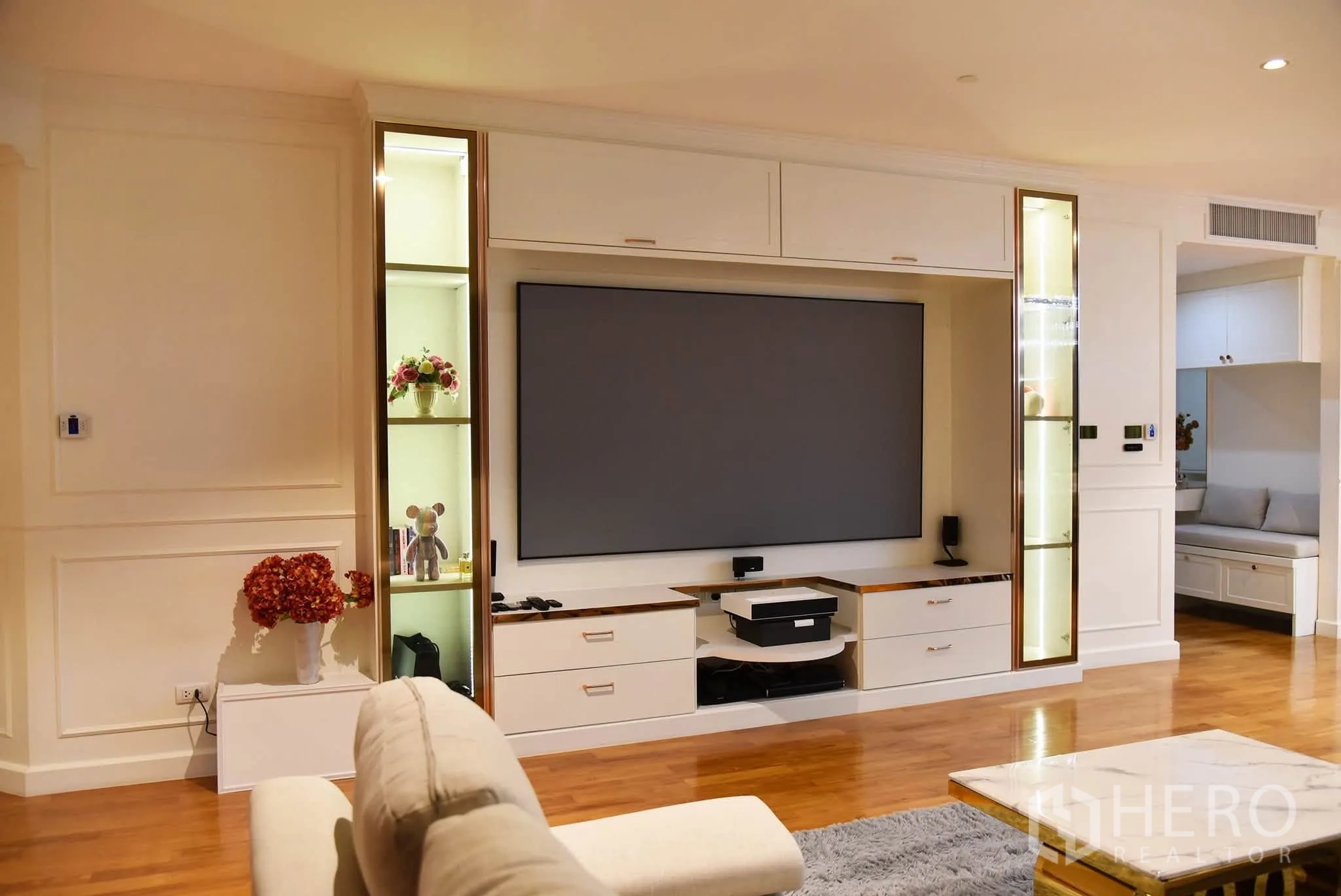 Condominium for sale in Khlong San, Bangkok - Close-up of the TV feature wall with illuminated niches and storage cabinets.