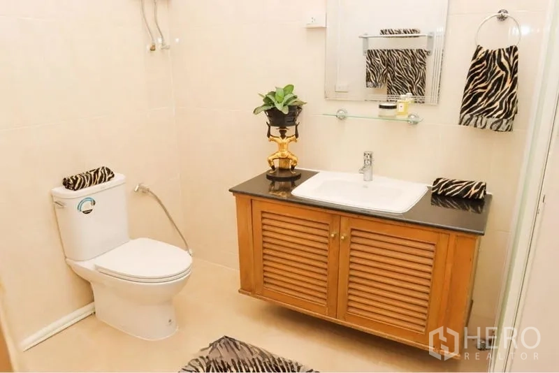 อพาร์ทเมนท์ ให้เช่าในPathum Wan, Bangkok - ห้องน้ำที่สอง พร้อมเคาน์เตอร์ท็อปสีดำ ตู้ซิงก์ และผ้าเช็ดตัวลายม้าลาย