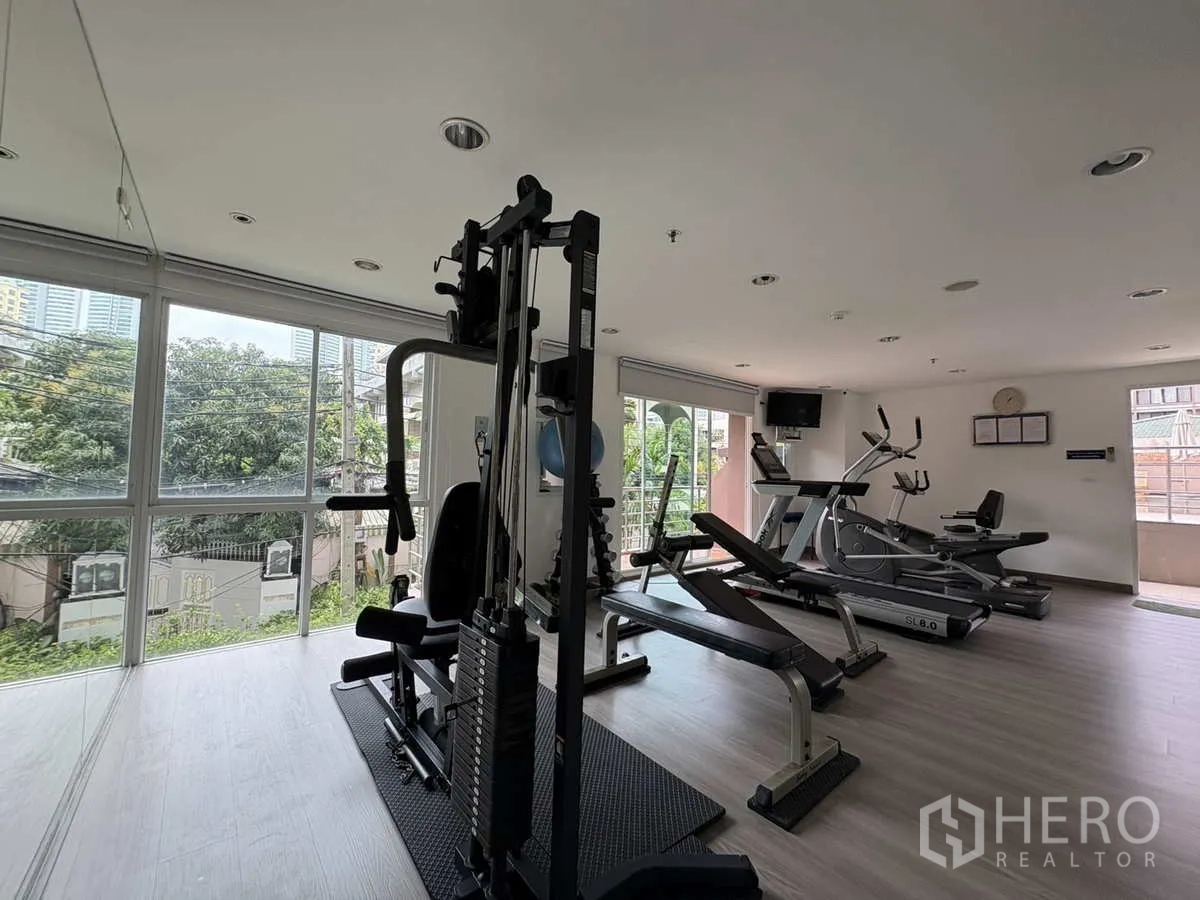 公寓 出租在Khlong Toei, Bangkok - 健身房配力量与有氧设备，落地窗享城市景观。