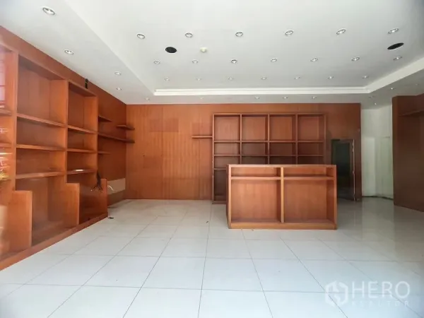 พื้นที่ขายปลีก ให้เช่าในKhlong Toei, Bangkok - พื้นที่หน้าร้านมีชั้นโชว์ไม้จำนวนมาก เคาน์เตอร์บริการ และไฟดาวน์ไลต์ฝังฝ้า