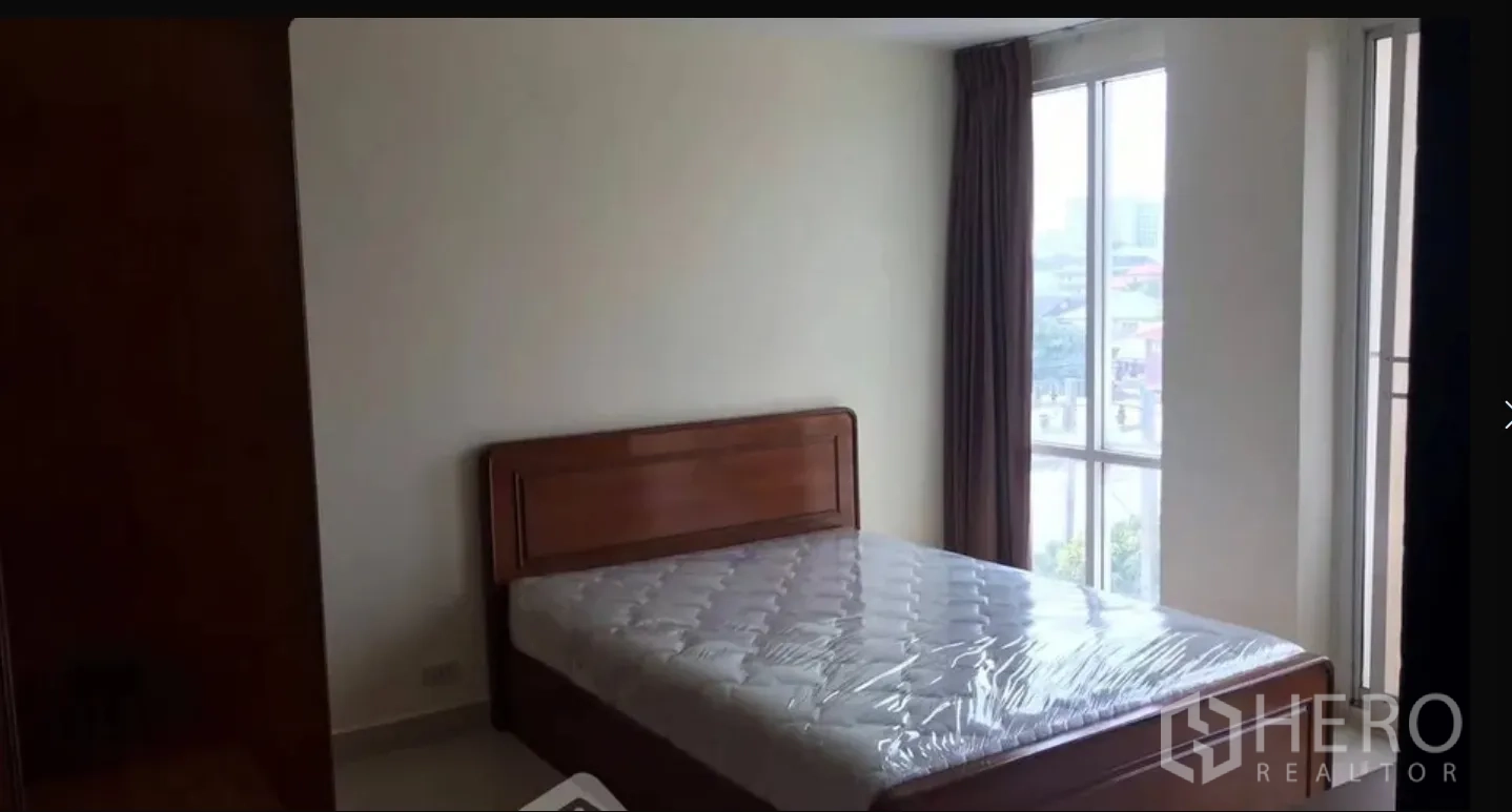 公寓 for sale in Watthana, Bangkok - 明亮卧室带床与落地窗，可见城市景观。