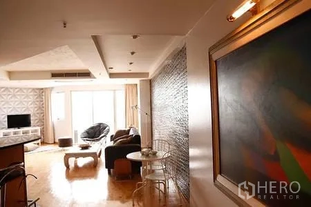 Condominium for rent in Ratchathewi, Bangkok - Bright condo living area with wood flooring, feature wall, large windows and lounge seating.