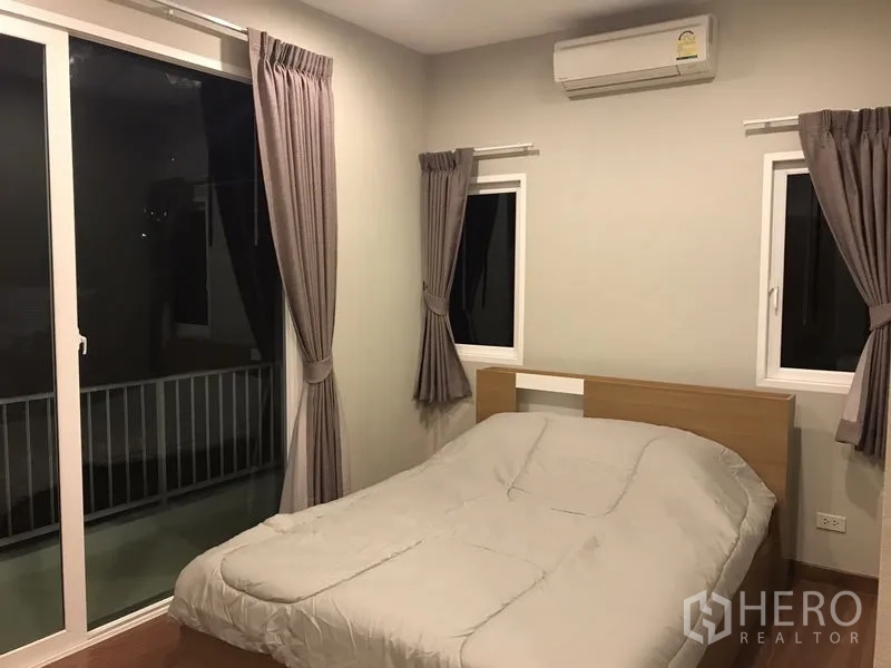 Detached House for rent or sale in Bang Na, Bangkok - Bedroom with double bed, air conditioning and sliding doors to the balcony.